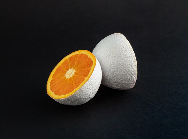 Fruit orange de couleur blanche sur fond noir Concept alimentaire minimal Idée abstraite