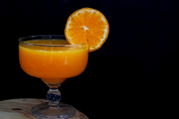 Photo le fruit orange frais fait le jus d'orange dans un verre sur le fond noir