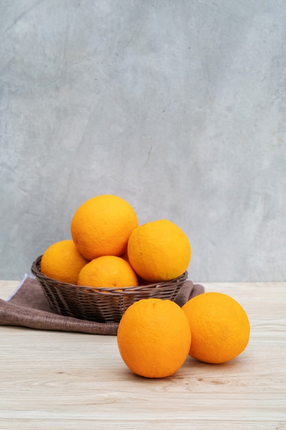 Fruit d&#39;oranges dans un panier sur une table en bois.