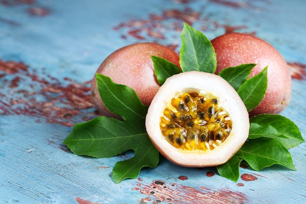 Fruit de la passion avec feuilles d&#39;origine sur fond en bois bleu