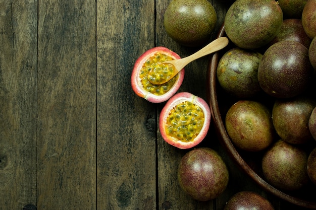 Fruit de la passion frais dans un bol en bois sur la surface de la table