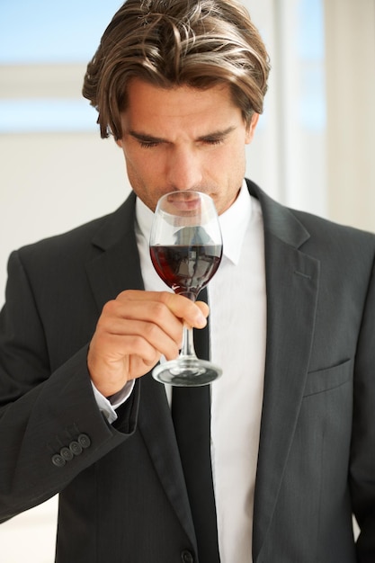 Fruité mais ludique Un beau connaisseur de vin dégustant un verre de vin rouge