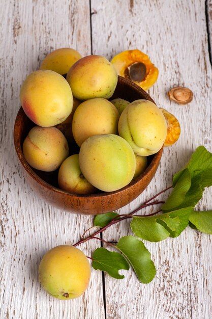 Fruits d'abricots biologiques mûrs dans un bol en bois de frêne