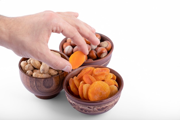 Fruits d'abricots secs sains avec des noix placées sur un fond blanc.