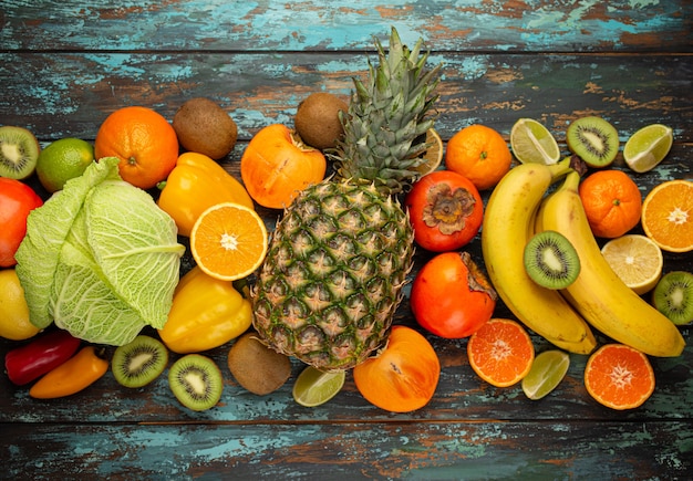 Fruits, agrumes, légumes à la vitamine C, vue de dessus de fond rustique en bois. Sources naturelles de vitamine C pour la stimulation de l'immunité, contre les virus et l'avitaminose. Une alimentation saine pour renforcer le système immunitaire