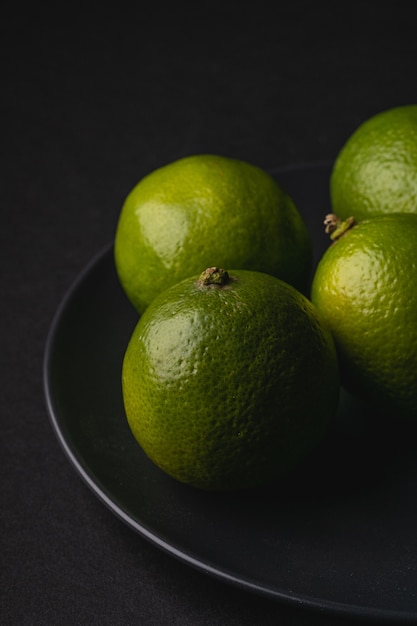 Fruits aigres de lime en plaque noire sur dark moody