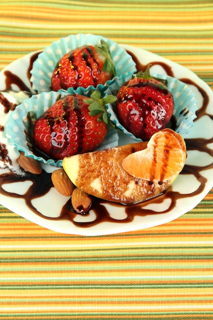 Fruits au chocolat sur plaque sur nappe libre