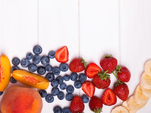 Fruits et baies sur table en bois blanc