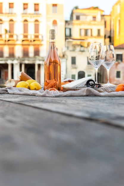 Fruits et collations au vin de rose sur la jetée en bois lors d'un pique-nique pittoresque sur le quai en bois