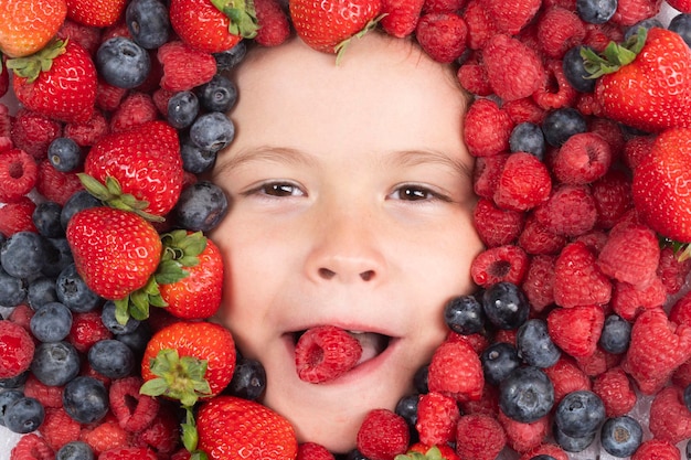 Fruits d'été Mélange de fond fraise myrtille framboise mûre Baies se bouchent près du visage des enfants Vue de dessus de baies fraîches Mélange de fruits de baies fraîches crues