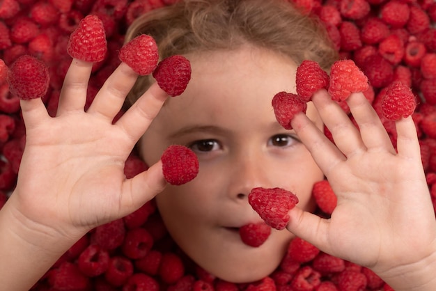 Fruits d'été vue de dessus photo du visage de l'enfant sur fond de framboises alimentation saine