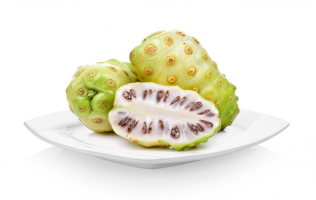 Fruits exotiques, fruits Noni en plaque blanche sur espace blanc