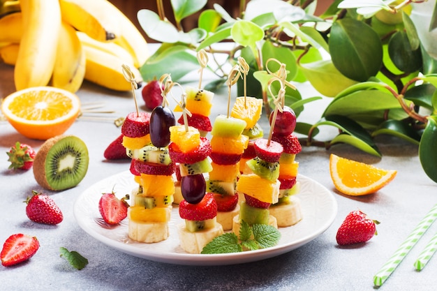 Fruits frais en brochettes. Buffet concept pour une fête d'été.