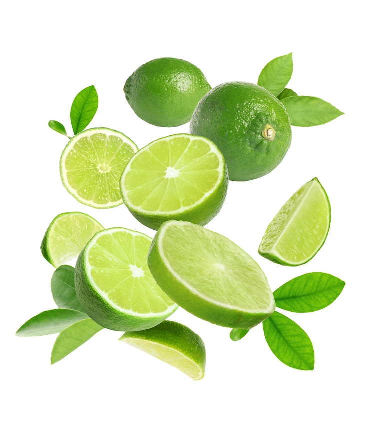 Photo des fruits frais de citron et des feuilles vertes tombant sur un fond blanc