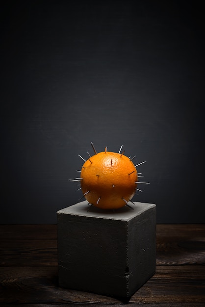 Photo fruits frais sur fond sombre sur un support en béton. orange juteuse avec des épines acérées.