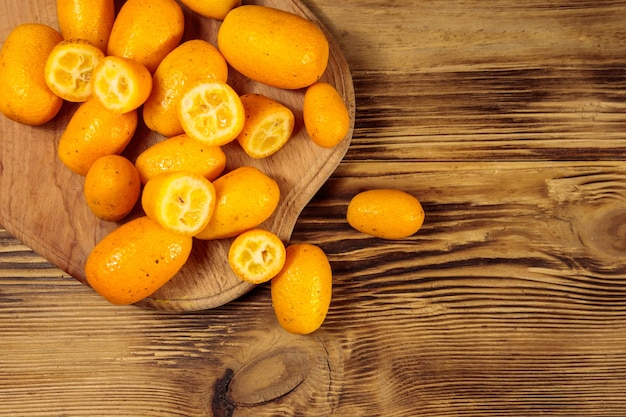 Fruits frais de kumquat sur table en bois