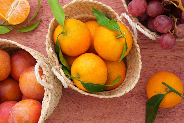 Fruits frais de mandarine dans un petit panier tressé. Vue de dessus