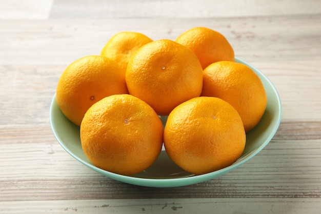 Fruits frais de mandarines sur bol de menthe sur fond de bois gris. Vue de dessus.
