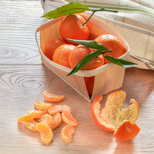 Fruits frais de mandarines avec des feuilles sur table en bois