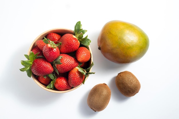 Fruits frais mangue fraise kiwi sur fond blanc vue de dessus mise à plat