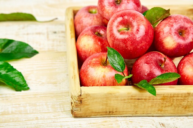 Fruits frais pommes mûres rouges dans la boîte en bois