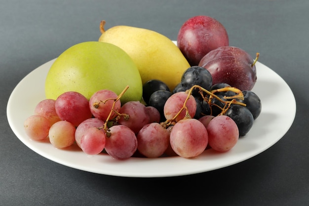 Fruits frais raisin prune pomme poire dans l'assiette