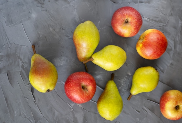 Fruits frais sur une vue de dessus de fond gris, pommes, raisins se bouchent