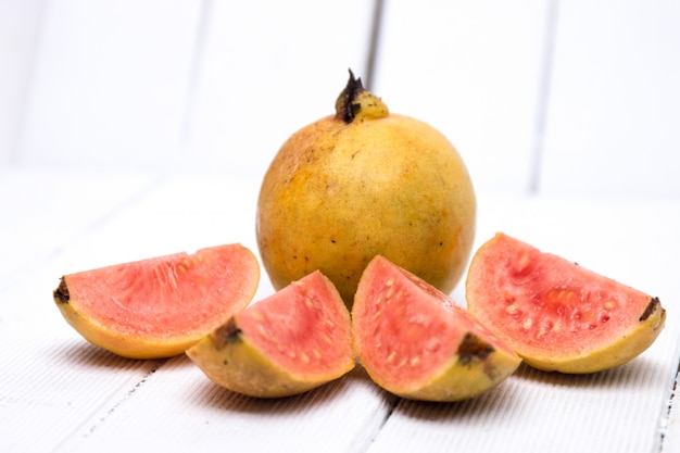 Fruits de goyave frais sur fond blanc.