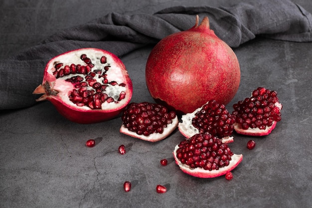 Fruits de grenade mûrs sur fond sombre.