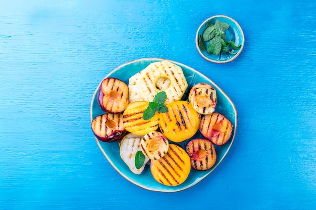 Fruits grillés avec des feuilles de menthe sur une plaque