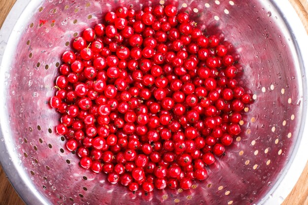 Fruits de groseille rouge dans la passoire en métal