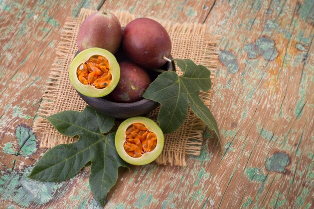 Fruits de gulupa sur table en bois de vigne Passiflora pinnatistipula