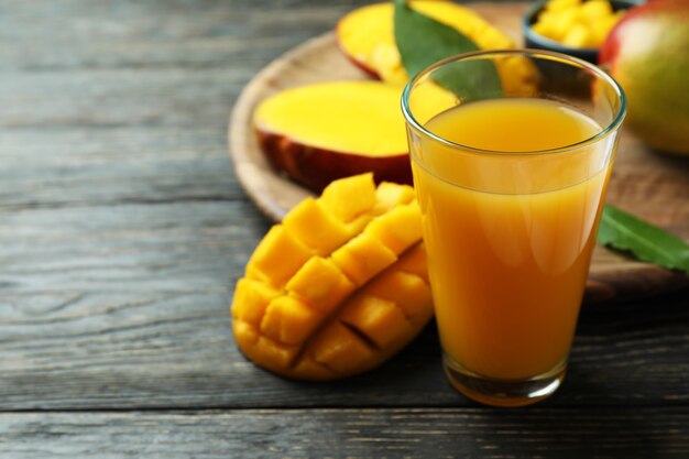 Fruits et jus de mangue mûrs sur table en bois