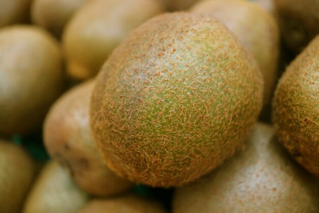 Fruits de kiwi frais fermés sur une pile de fruits de kiwi floue