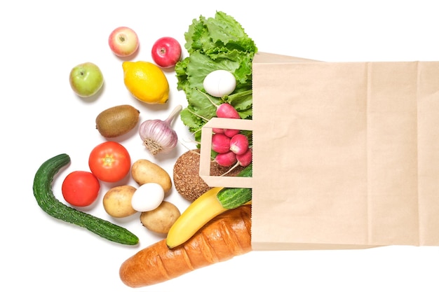 Fruits légumes et produits dans un sac d'épicerie en papier sur fond blanc