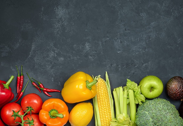 Les fruits et légumes sont disposés en rang sur un fond de béton noir