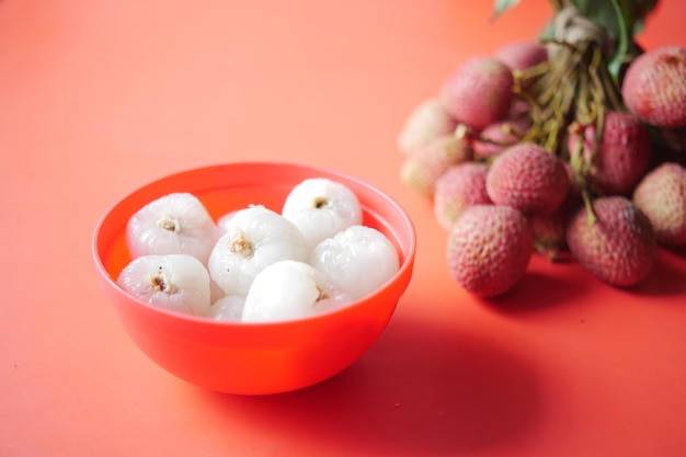 fruits de litchi dans un bol de couleur rouge