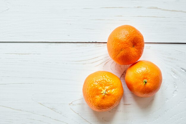 Fruits de mandarine sur une table en bois blanc