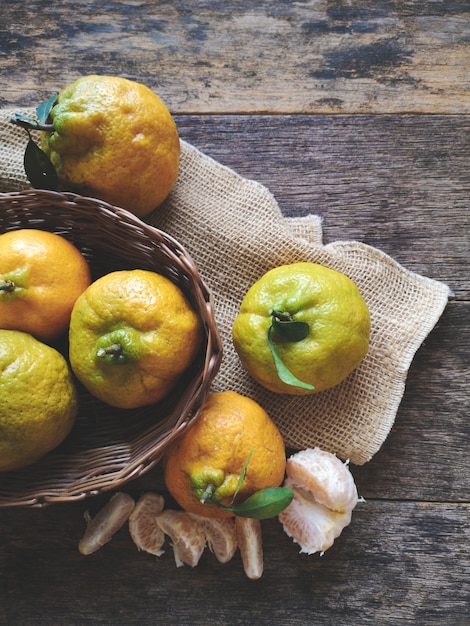 Fruits de mandarines dans le panier sur fond de bois rustique.