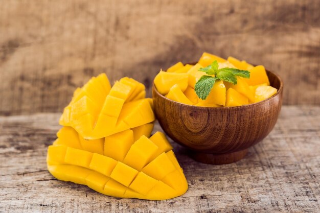 Fruits de mangue et cubes de mangue sur la table en bois