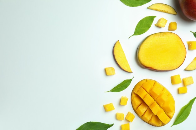 Fruits de mangue mûrs sur une surface blanche, vue de dessus