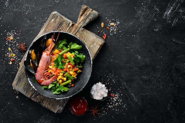 Fruits de mer aux légumes Légumes bouillis aux crevettes et moules Dans une assiette noire Vue de dessus Espace de copie gratuit