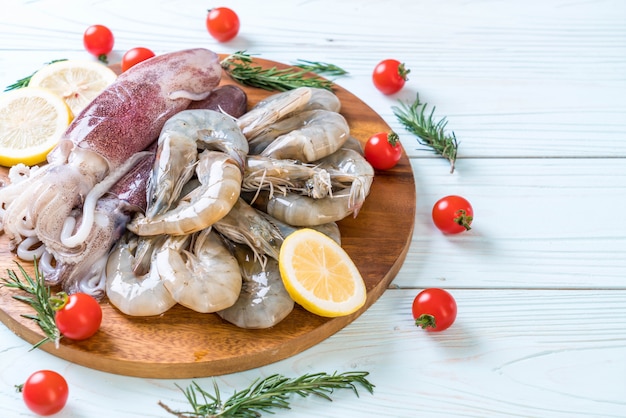 fruits de mer crus (crevettes, calmars) sur planche de bois