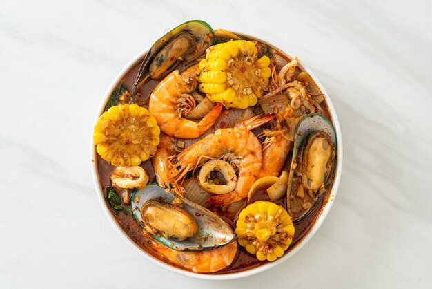 fruits de mer épicés au barbecue - crevettes, calmars, moules et maïs