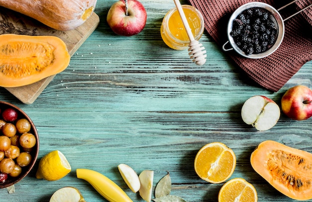 Fruits et miel dans un pot sur la vue de dessus de table en bois brut turquoise vieilli