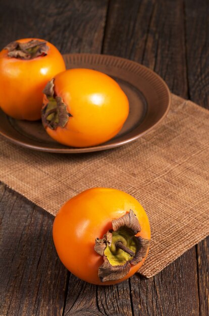 Fruits mûrs de kaki sur table en bois rustique