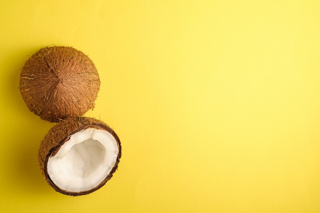 Fruits de noix de coco sur une surface unie jaune