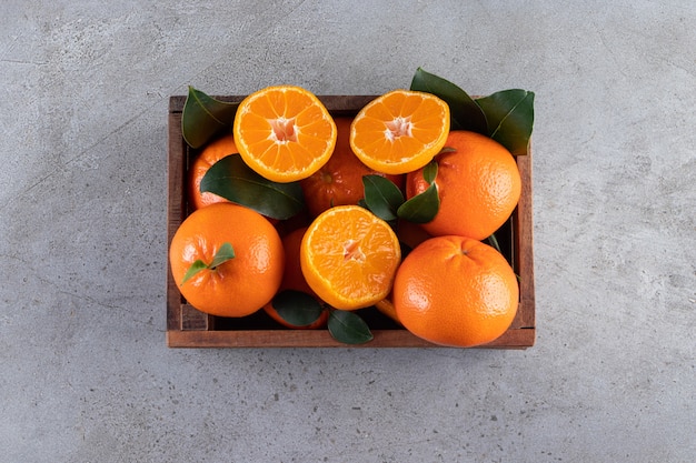 Fruits Orange Frais Entiers Et Tranchés Avec Des Feuilles Placées Dans Une Vieille Boîte En Bois
