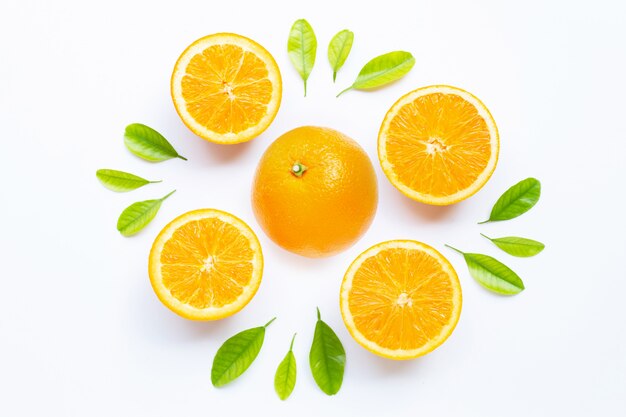 Fruits orange frais avec des feuilles vertes sur blanc.