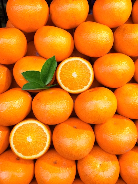 Photo fruits orange frais avec des feuilles en vue de dessus en arrière-plan